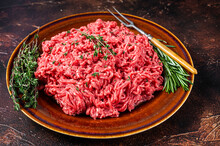 Raw Mince Beef And Lamb Meat On A Rustic Plate With Herbs. Dark Background. Top View
