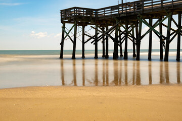 pier on beach; long exposure creates silky effect with water.