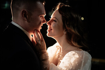 profiles of the bride and groom in the dark in a counter-light.