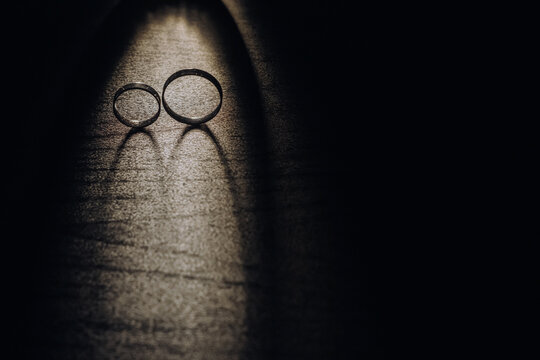 Close-up of two gold wedding rings on a black background