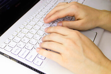 A person using a laptop computer sitting on top of a keyboard