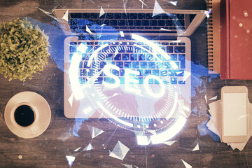 Double exposure of SEO drawing over study table background with computer. Concept of search. Top view.