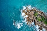 Fototapeta Do pokoju - Drone field of view of waves crashing into rocky peninsula in Praslin, Seychelles.