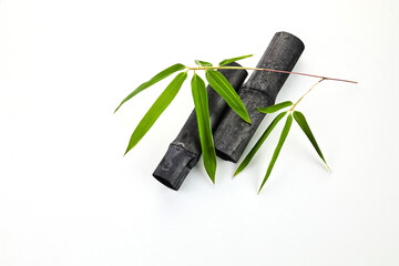 Natural bamboo charcoal stocks with leaves isolated on white background