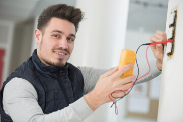 electrician checking socket voltage using multimeter