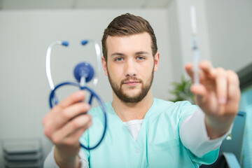 young man doctor with stethoscope preparing a injection