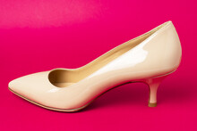 Classic Beige Patent Leather Shoe With Low Kitten Heel On Purple Background.