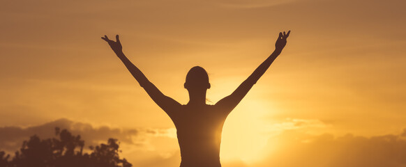 Wall Mural - Happy woman with hands up to the sunset sky. Positive energy, prayer and gratitude concept.	