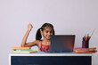 © Ojas - Little girl studying online using her laptop or computer at home.
