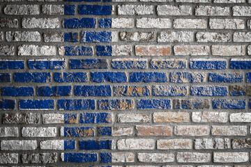 Wall Mural - National flag of Finland. depicting in paint colors on an old brick wall. Flag  banner on brick wall background.