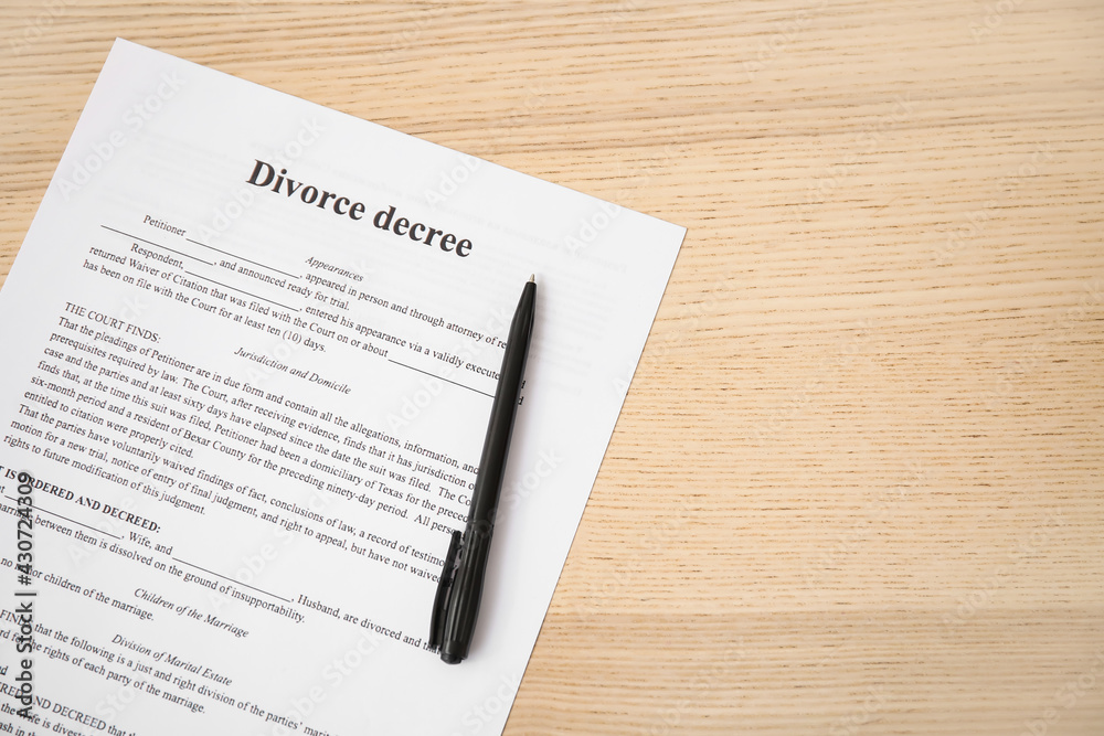 Divorce decree with pen on wooden background