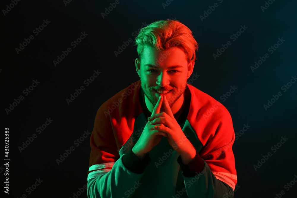 Toned portrait of handsome young man on dark background