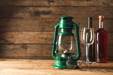 Stylish Retro Lamp, Eyeglasses And Bottles Of Wine On Wooden Background