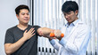 © Ngampol - Young asian physiotherapist helping male patient stretching arm during exercise correct with dumbbell