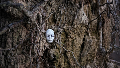 stone face on dark earth background with roots. Fantasy mystical image of earth and man. Nature and man, druid and wicca symbol, Element earth concept.