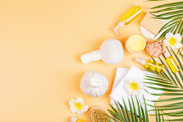 Sticker - Spa massage Aromatherapy body care background. Spa herbal balls, cosmetics, towel and tropical leaves on orange table. Top view, flat lay, overhead, copy space. Beauty and health care concept