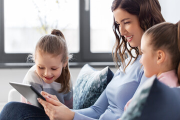 Sticker - people, family and technology concept - happy mother and two daughters with tablet pc computer at home