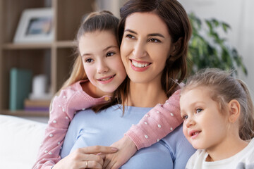 Wall Mural - people, family and love concept - happy smiling mother with two daughters at home