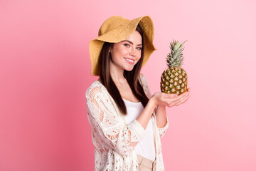 Poster - Portrait of adorable satisfied lady arms holding pineapple look camera toothy smile isolated on pink color background