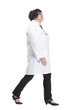 © ASDF - older female doctor with a stethoscope walks forward.