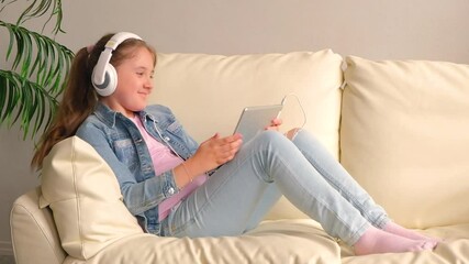 Wall Mural - The child in the headphones with the tablet. T