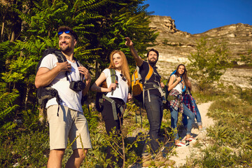 Wall Mural - happy tourists with backpacks travel in the mountains in nature in summer. tourism. hiking.