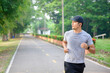 © เลิศลักษณ์ ทิพชัย - Asian handsome young man Doing exercise by running in the park Sweating from morning workouts