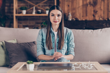 Sticker - Photo of serious young attractive woman sit sofa calm face wear casual clothes indoors inside house