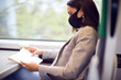 © Monkey Business - Businesswoman On Train Relaxing And Reading Book Wearing PPE Face Mask During Health Pandemic
