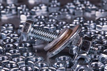 Metal chrome bolts and nuts in a chaotic order industrial background