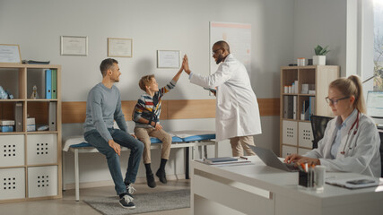 Wall Mural - Father Visiting a Friendly Family Doctor with His Young Teenage Son Who Has Broken His Arm, Give High Five. They Talk to an African American Physician in a Hospital Office. Boy is Wearing an Arm Brace