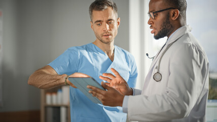 Wall Mural - Doctor's Office: African American Physician Talks With Professional Male Nurse, Using Tablet Computer. Medical Health Care Specialists Discuss Test Results, Prescription Medicine, Patient Treatment.