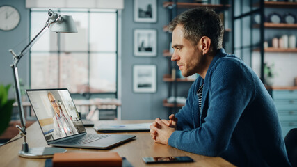 Aufkleber - Handsome Caucasian Man Having a Video Call with Female Doctor on Laptop Computer while Sitting Behind Desk in Living Room. Freelancer Working From Home and Talking a Medic Over the Internet.