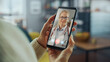© Gorodenkoff - Close Up of a Female Chatting in a Video Call with Her Black Male Family Doctor on Smartphone from Living Room. Ill-Feeling Woman Making a Call from Home with Physician Over the Internet.