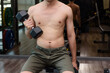 © Vatcharachai - Fitness man are training or exercising by lifting dumbbells. in Fitness room at sport gym...
