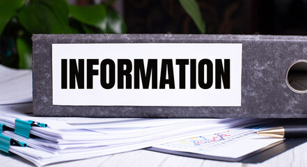 Fototapete - The words INFORMATION is written on a gray file folder next to documents. Business concept