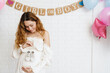 Young happy pregnant woman posing with baby shoes during gender party