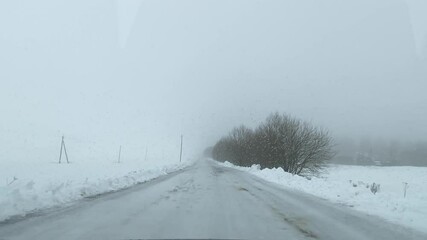 driving in a car on a winter country road during bad rainy weather
