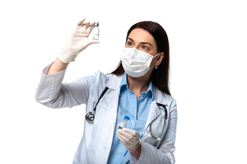 Wall Mural - Brunette doctor in medical mask looking at vaccine isolated on white