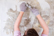 Caucasian man tearing off old wallpaper from wall preparing for home redecoration