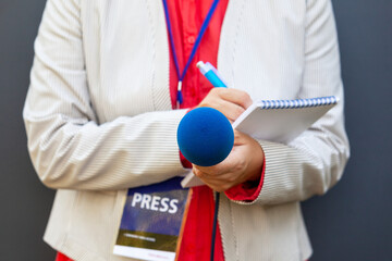 Wall Mural - Female journalist or reporter at news conference or media event. Journalism concept.