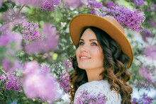 Portrait Of A Beautiful Young Woman In A Blooming Lilac Park. Purple Flowers. Spring. Happiness.