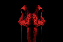 Mystery Cult Members In A Red Hooded Cloaks In The Dark. Unrecognizable Person. Hiding Face In Shadow. Ghostly Figure. Sectarian. Conspiracy Concept.	