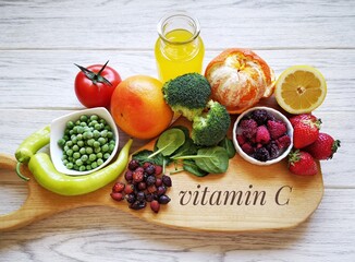 Wall Mural - Food high in vitamin C for strong immune system. Assortment of natural products rich in vitamin C. Fresh fruit and vegetable; best food sources of vitamin c tomato, juice, strawberry, pepper, spinach