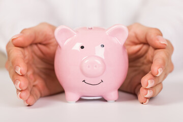 Wall Mural - Piggy bank in hand on light  background, space for text. Finance, saving money. Business to success and saving for retirement concept