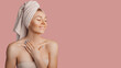 © Daria Lukoiko - Beautiful sensual young girl with clean skin on a pink background with a mockup. Topless woman in a towel. The concept of spa treatments, natural beauty and care, youth, cream and mask, freshness