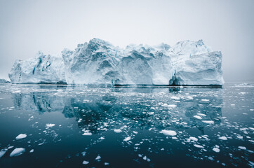 Wall Mural - Arctic nature landscape with icebergs in Greenland icefjord with midnight sun sunset sunrise in the horizon. Early morning summer alpenglow during midnight season. Ilulissat, West Greenland.