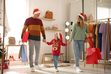 Canvas Print - Happy family with Santa hats doing Christmas shopping in store