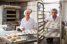Fine Baker Placing Tray With Formed Raw Dough On Rack Trolley For Proofing.