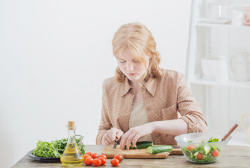 teen girl prepares salad at home